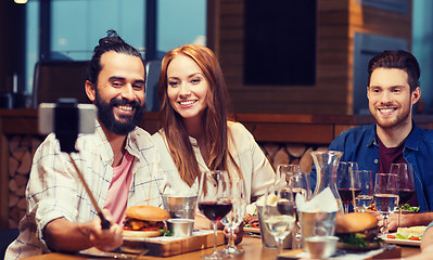 Image showing friends taking selfie by smartphone at restaurant