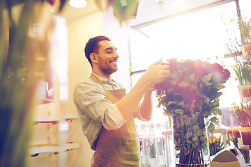 Image showing smiling florist man with roses at flower shop