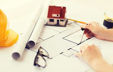 Image showing close up of hands with compass measuring blueprint