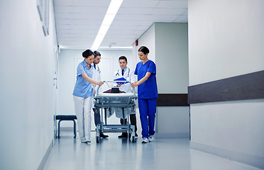 Image showing medics and patient on hospital gurney at emergency