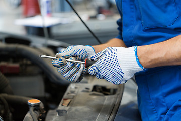 Image showing mechanic man with wrench repairing car at workshop