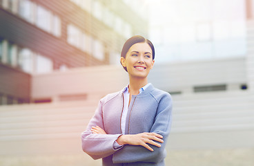 Image showing young smiling businesswoman over office building