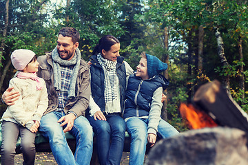 Image showing happy family sitting on bench at camp fire