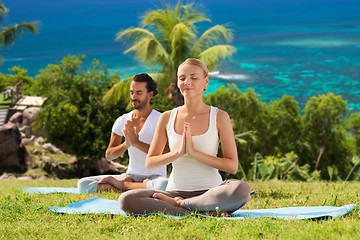 Image showing happy couple doing yoga and meditating outdoors