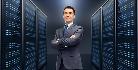 Image showing smiling businessman over server room background