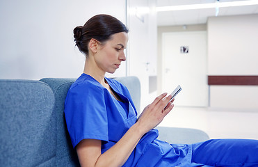 Image showing female doctor or nurse with smartphone at hospital