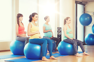 Image showing happy pregnant women exercising on fitball in gym