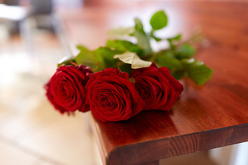 Image showing red roses on bench at funeral in church