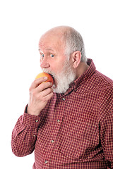 Image showing Cheerfull senior man eating the apple, isolated on white