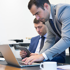 Image showing Business team remotely solving a problem at business meeting using laptop computer and touchpad.