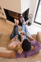 Image showing Young multiethnic couple  in front of fireplace