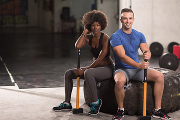 Image showing multiethnic couple after workout with hammer