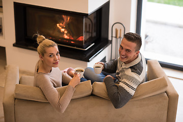 Image showing Young couple  in front of fireplace