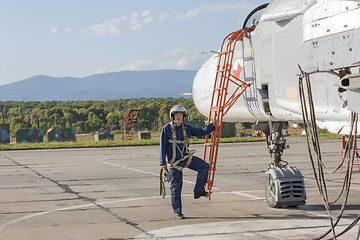 Image showing Military pilot in helmet stands near jet plane