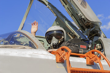 Image showing Military pilot in cockpit jet plane with a raised hand