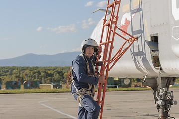 Image showing Military pilot in helmet stands near jet plane