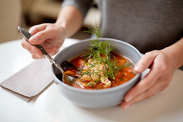 Image showing woman eating seafood soup at restaurant