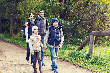 Image showing happy family with backpacks hiking in woods