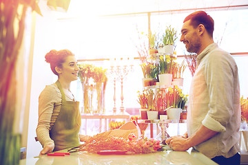 Image showing smiling florist woman and man at flower shop