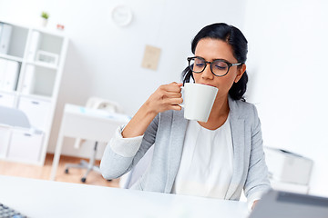 Image showing businesswoman drinking coffee or tea at office