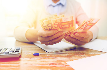 Image showing close up of senior woman counting money at home