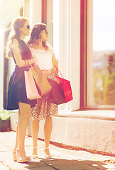 Image showing happy women with shopping bags at shop window