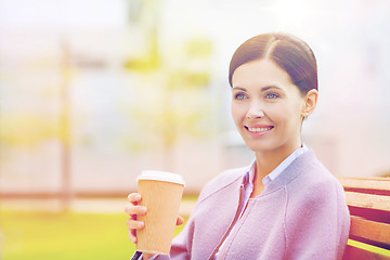 Image showing smiling woman drinking coffee outdoors