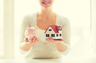 Image showing close up of woman with house model and piggy bank