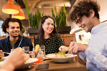 Image showing happy friends eating and drinking at restaurant