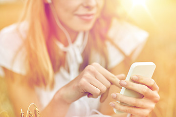 Image showing close up of woman with smartphone and earphones