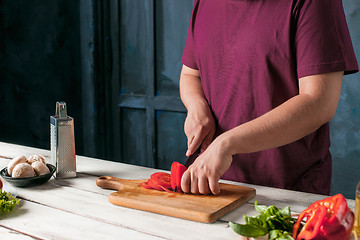 Image showing Closeup hand of chef baker making pizza at kitchen