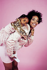 Image showing young pretty african-american mother with little cute daughter hugging, happy smiling on pink background, lifestyle modern people concept 