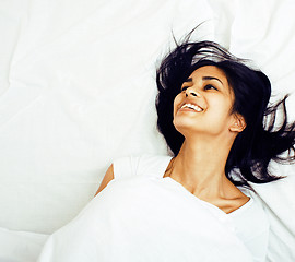 Image showing young pretty tann woman in bed among white sheets having fun, tr