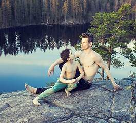 Image showing middle age man with little cute son doing sport yoga on the top of the mountain together, happy family lifestyle people outdoor, summer wild nature for training close up