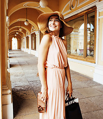 Image showing young pretty smiling woman in hat with bags on shopping at store