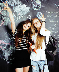 Image showing back to school after summer vacations, two teen real girls in classroom with blackboard painted together, lifestyle people concept