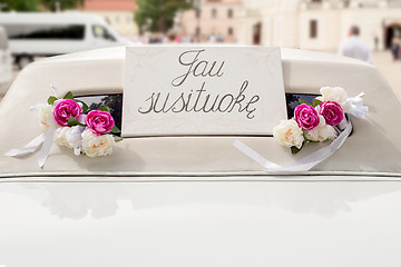 Image showing White wedding limousine decorated with flowers