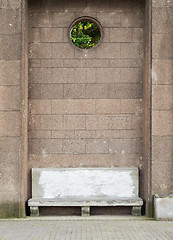 Image showing Ancient stone bench near the big brick wall