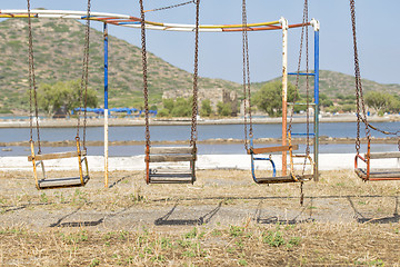 Image showing old swings in playground near the sea