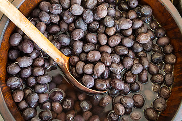 Image showing Olives in wooden bowls with serving spoon.