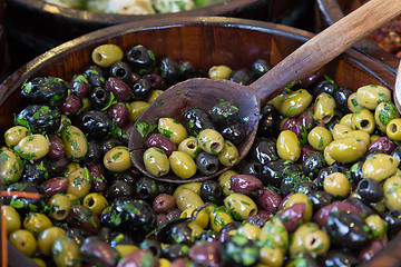 Image showing Olives in wooden bowls with serving spoon.