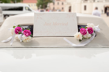 Image showing White wedding limousine decorated with flowers