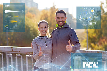 Image showing smiling couple showing thumbs up outdoors