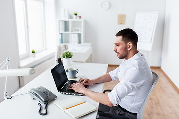 Image showing businessman typing on laptop at office