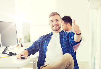 Image showing happy creative man with computer at office