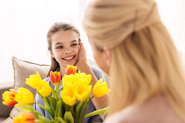 Image showing happy girl giving flowers to mother at home