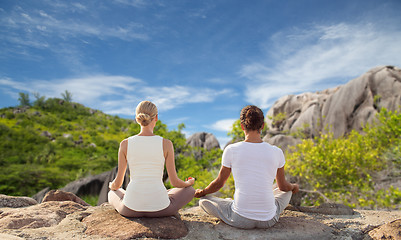 Image showing couple meditating in yoga lotus pose outdoors