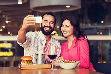 Image showing couple taking selfie by smartphone at restaurant