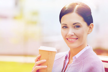 Image showing smiling woman drinking coffee outdoors