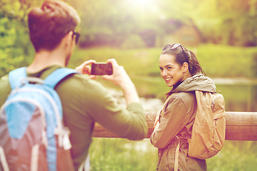 Image showing couple with backpacks taking picture by smartphone